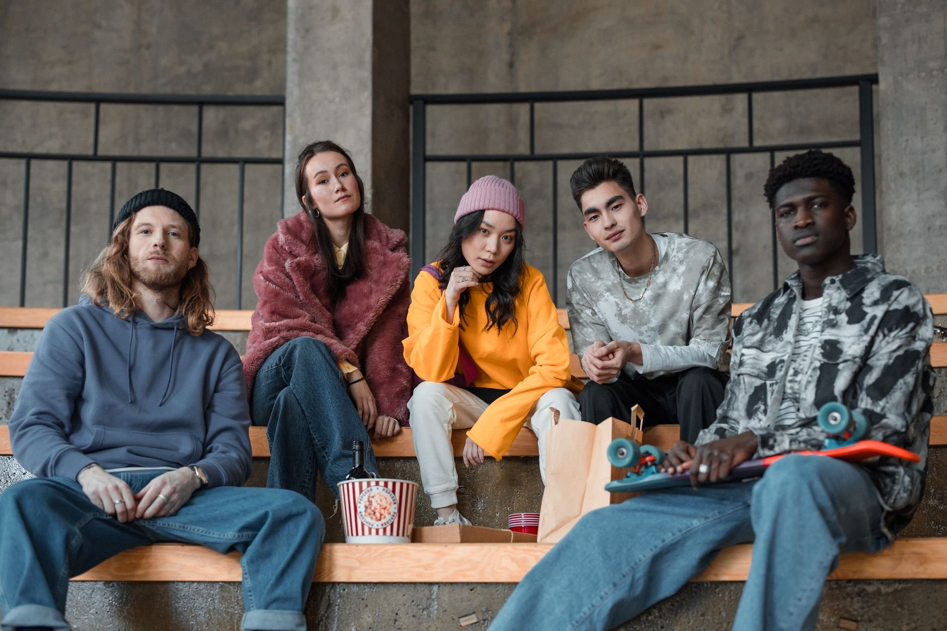A diverse group of fashionable young adults sitting indoors, showcasing modern style and friendship.